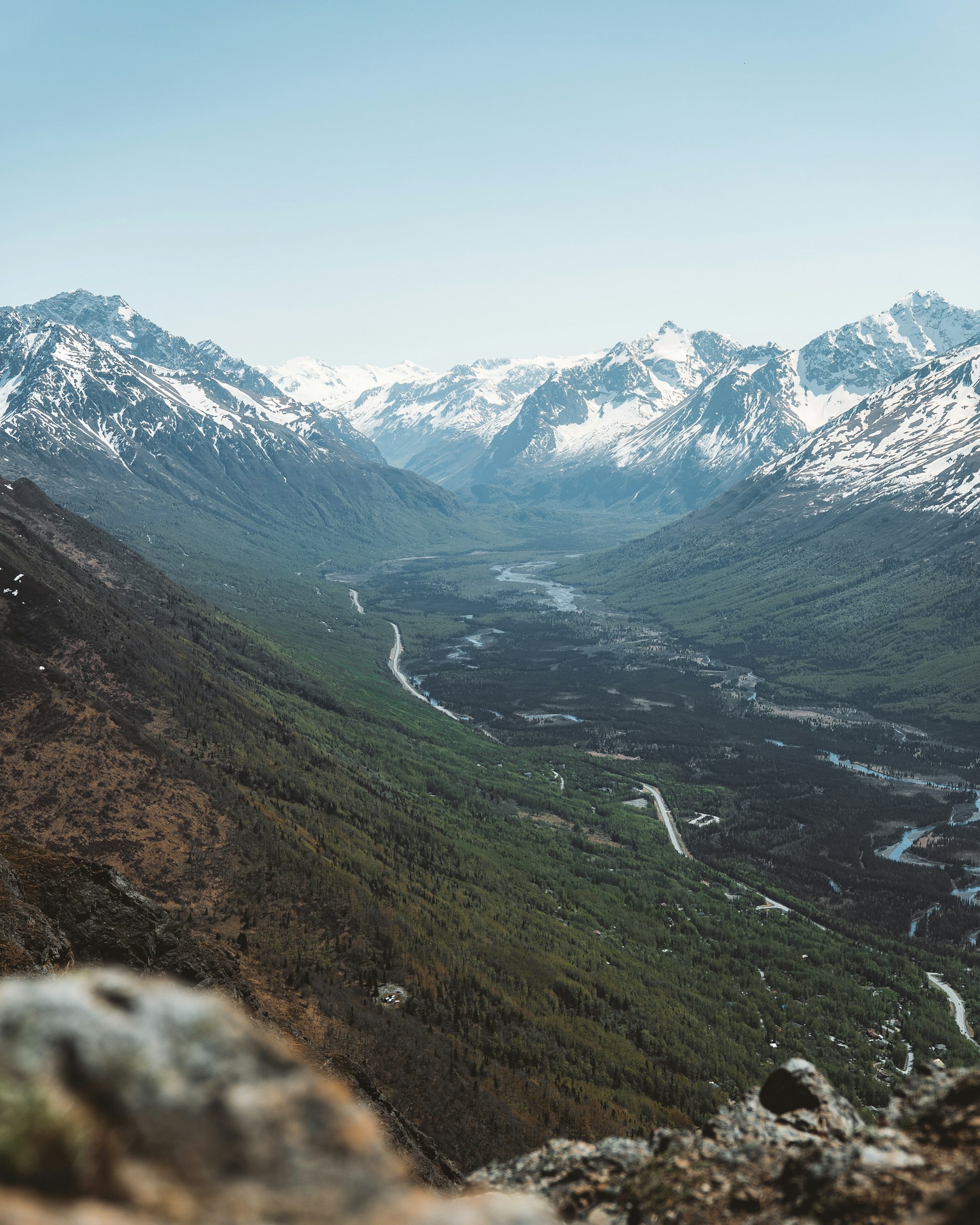 Snow-capped Alaska mountains above a green river valley